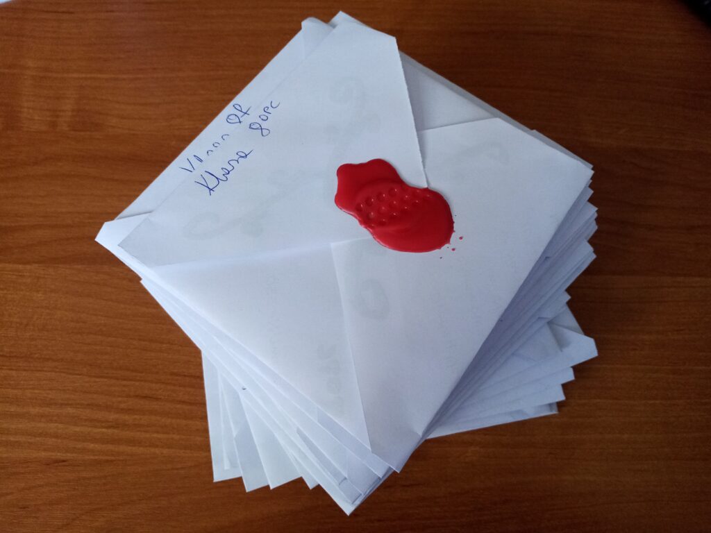 Stos listów zalakowanych czerwonym woskiem.